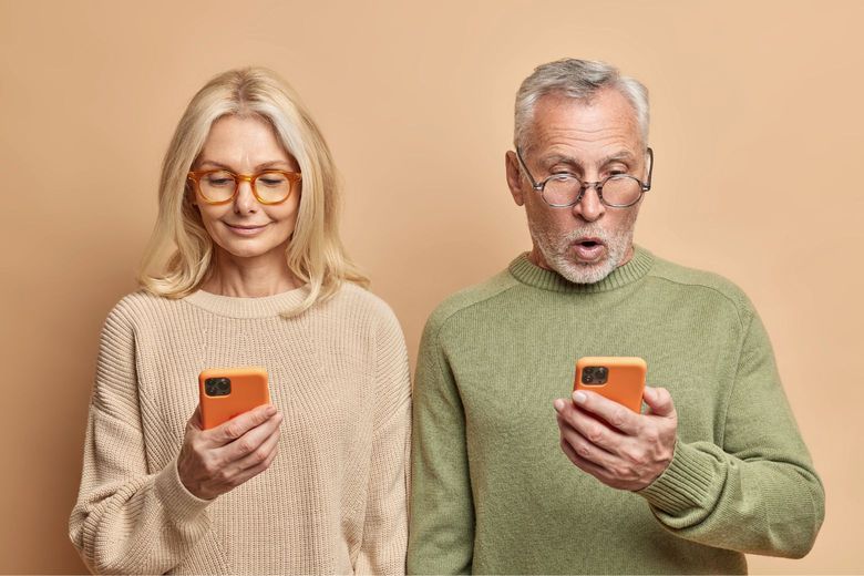 two people looking at mobile screens with different expressions